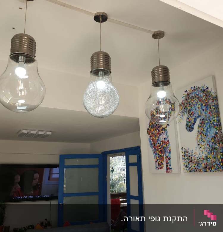 שלושה גופי תאורה תלויים עם נורות גדולות